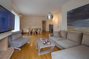 uma sala de estar com um sofá e uma mesa em Sagittarius - Faliro Sea Side apartment em Atenas