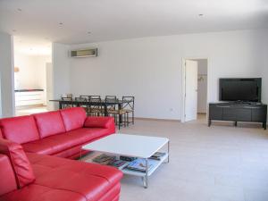 a living room with a red couch and a tv at Casa Bonita in Algarrobo
