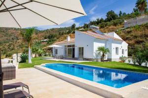 a villa with a swimming pool in front of a house at Casa Bonita in Algarrobo