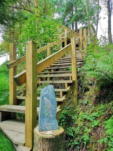 a wooden staircase with a sign on the side of it at Llethrau Forest & Nature Retreats in Knighton
