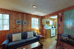 een woonkamer met een bank en een keuken bij Traditional Maine Cabin in Greenville