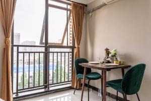 comedor con mesa y sillas y ventana grande en Wuhan Hongshan·Guanggu Square· Locals Apartment 00157650, en Wuhan