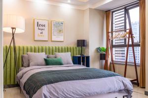 a bedroom with a bed with a green headboard at Wuhan Hongshan·Guanggu Square· Locals Apartment 00157650 in Wuhan