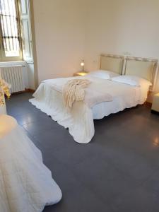 - une chambre avec un grand lit et des draps blancs dans l'établissement CharmeRooms Villa Moroni, à Stezzano