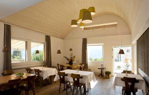 a dining room with tables and chairs and windows at Landhus Almens in Almens