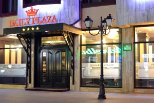 uma luz de rua em frente a um edifício com uma loja em Daily Plaza Hotel em Suceava