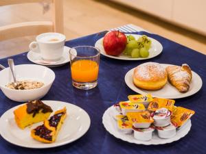 een blauwe tafel met borden ontbijtproducten en een kopje koffie bij Hotel Villa Sorriso in Senigallia