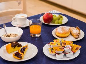 una mesa azul con platos de desayuno y una taza de café en Hotel Villa Sorriso, en Senigallia