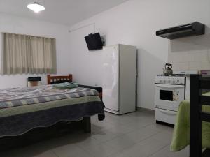 een kamer met een bed, een koelkast en een fornuis bij Los Alamos in Puiggari