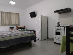a room with a bed and a refrigerator and a stove at Los Alamos in Puiggari