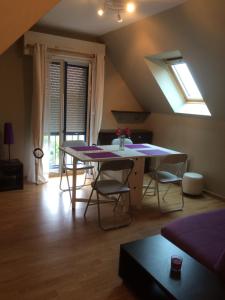 sala de estar con mesa y ventana en résidence les voiles rouges, en Saint-Jouan-des-Guérets