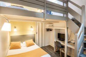 a hotel room with a bed and a tv at Au Patio Morand in Lyon