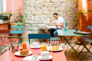 a table with plates of food and a man sitting at a table at Au Patio Morand in Lyon