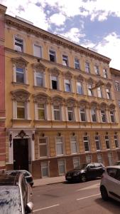 duży budynek z samochodami zaparkowanymi przed nim w obiekcie Vienna Smile Apartment Schoenbrunn w Wiedniu