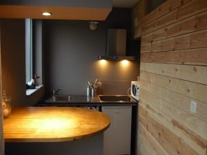a kitchen with a wooden counter top and a sink at La Lisière in Durbuy