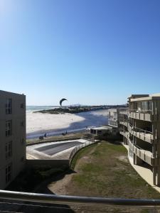 Blick auf den Strand vom Balkon eines Gebäudes in der Unterkunft A310 Lagoon Beach Apartment & Spa in Kapstadt