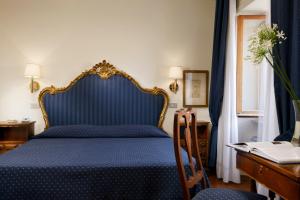 a blue bed in a room with a desk at Hotel Titano in San Marino