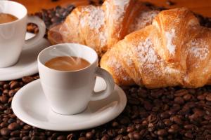 a table with two cups of coffee and some bread at A.J. B&B in Lesina
