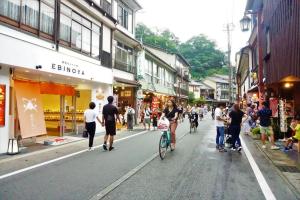 a group of people walking and riding bikes down a street at Morizuya in Toyooka +291 photos