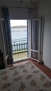 a room with a large window with a view of the water at Esperides Sea in Andros