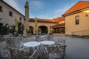 an outdoor patio with tables and chairs and an umbrella at Chateau Krakovany in Krakovany