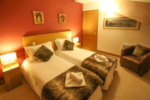 ein Hotelzimmer mit zwei Betten und einem Stuhl in der Unterkunft Time to Ski - Aramis in Sainte-Foy-Tarentaise