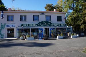 a large white building with a bar hotel at Hotel Pinede in Saint-Jean-de-Monts