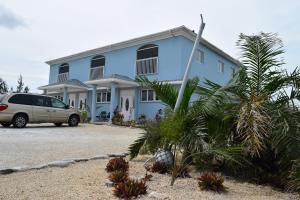 una casa blu con un furgone parcheggiato di fronte. di Royal Hideaway a Bambarra