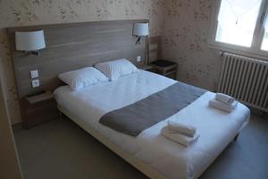 a bedroom with a large bed with two towels on it at Hotel Pinede in Saint-Jean-de-Monts