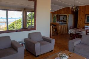 een woonkamer met een bank, stoelen en een tafel bij Melkboom in Franskraalstrand