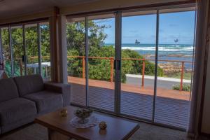 a living room with a couch and a view of the ocean at Melkboom in Franskraal