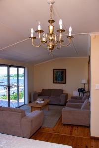 una sala de estar con 2 sofás y una lámpara de araña. en Melkboom en Franskraal