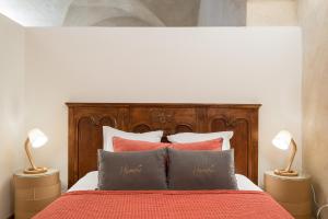 a bedroom with a bed with a wooden headboard and pillows at Honorê - Suite Romain Rolland in Lyon