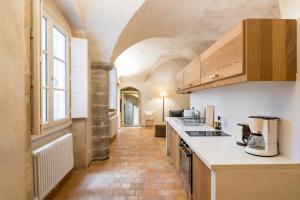 a kitchen with white countertops and a long hallway at Honor&ecirc; - Suite Romain Rolland in Lyon