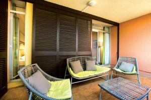 two wicker chairs sitting on a porch with at Hôtel Vacances Bleues Delcloy in Saint-Jean-Cap-Ferrat