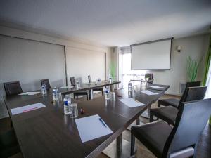 a conference room with tables and chairs and a screen at Hotel Inn Design Resto Novo Challans in Challans