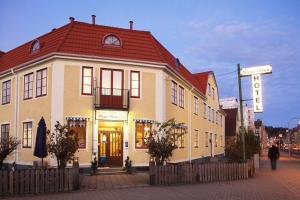 a building with a red roof on a street at Hotell Uddewalla in Uddevalla