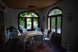 a dining room with a table and chairs and windows at Fattoria La Guedrara in Sestola