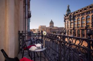 a table and chairs on a balcony with a view of the city at Novaya Istoria in Saint Petersburg