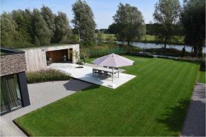 a lawn with a picnic table and an umbrella at B&B The View Bis in Kortrijk