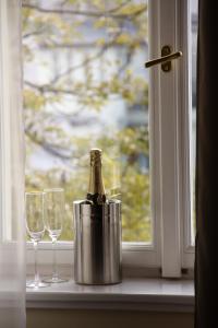 eine Flasche Champagner in einem Eimer neben zwei Gläsern in der Unterkunft Hotel Trevi in Prag