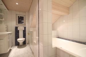 a bathroom with a toilet and a tub and a sink at Schwarzmann's Ferienwohnungen in Schröcken +51 photos