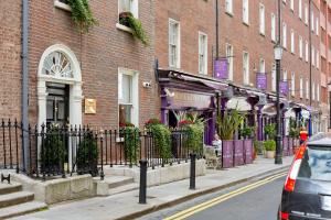 a brick building with a fence on a city street at Trinity Townhouse Hotel in Dublin