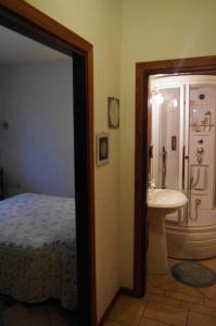 a bedroom with a bed and a bathroom with a sink at Fattoria La Guedrara in Sestola