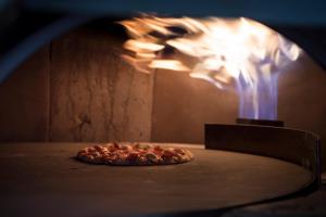 a pizza is coming out of an oven at Boro Hotel in Queens