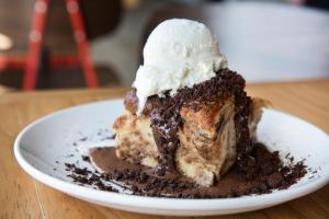 a piece of chocolate cake with ice cream on top at Boro Hotel in Queens