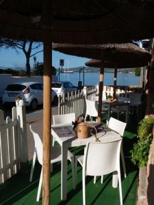 uma mesa e cadeiras sob um guarda-sol num pátio em Hotel Tabby em Golfo Aranci