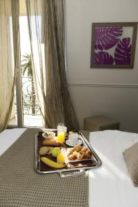 a tray of breakfast food on a bed at Hôtel Le Royal Promenade des Anglais in Nice