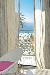 a view of the ocean from a balcony with a chair at Hôtel Le Royal Promenade des Anglais in Nice