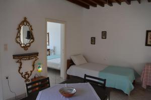 CherronisosにあるAmmos Holiday Houseのベッド2台、テーブル、鏡が備わる客室です。